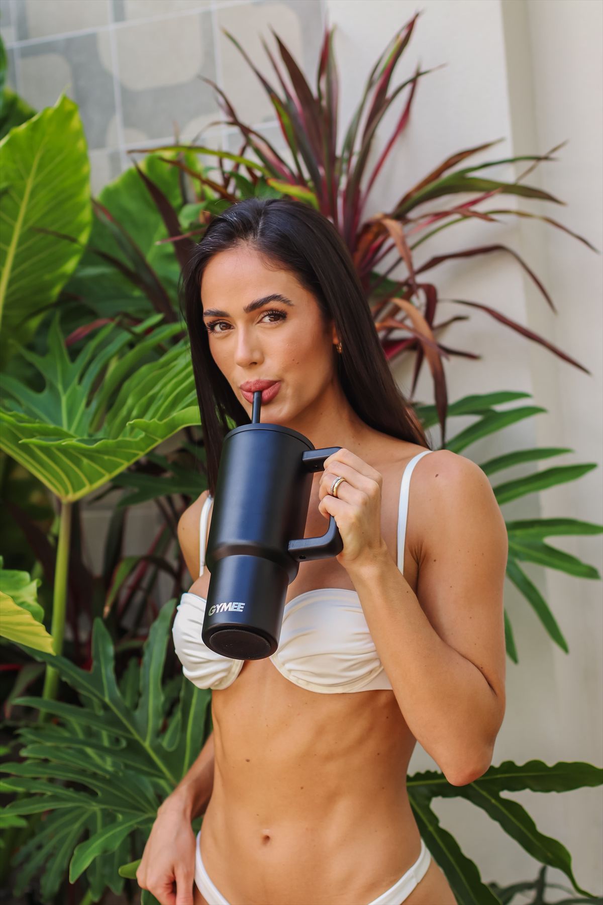 Modelo com garrafa GYMEE Cozy preta em jardim