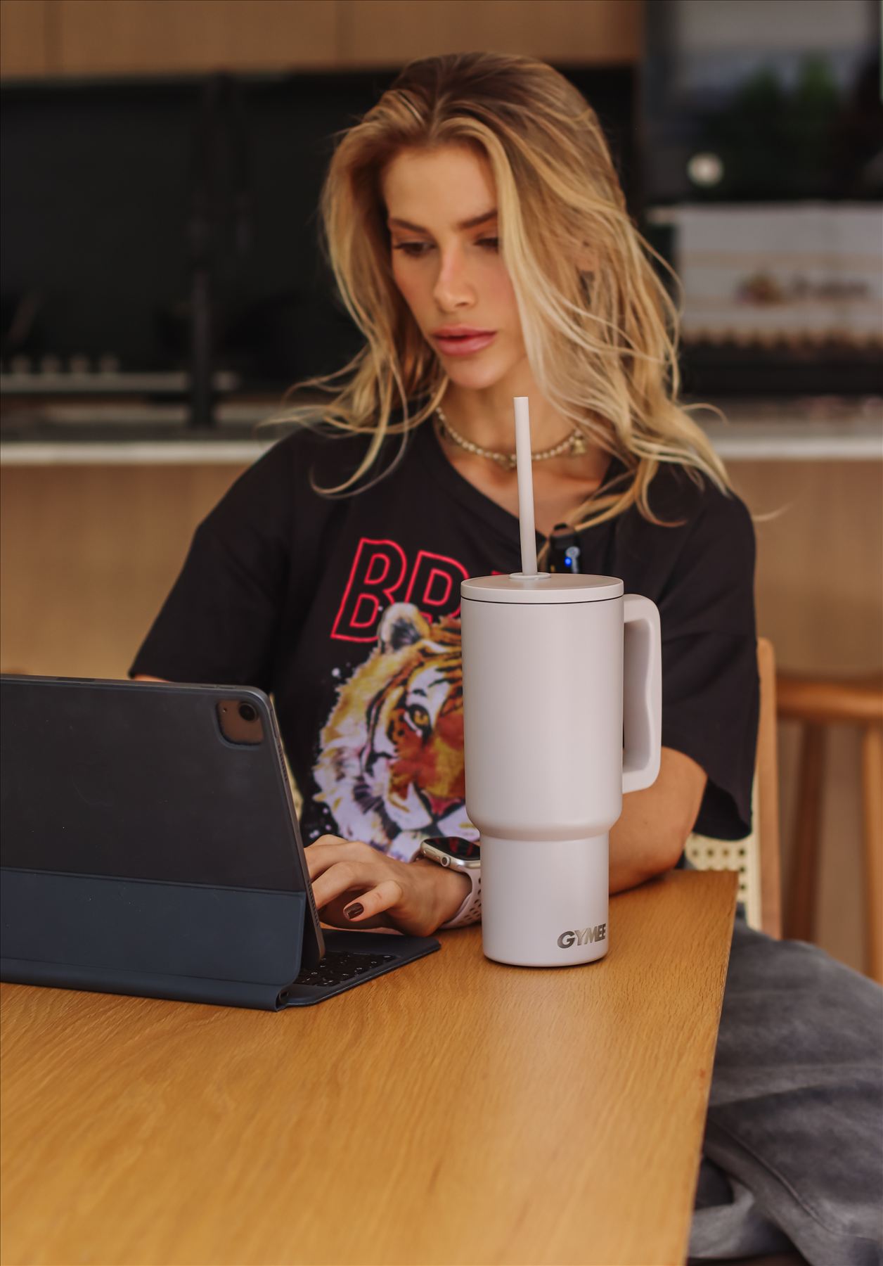 Mulher trabalhando em home office com garrafa térmica GYMEE