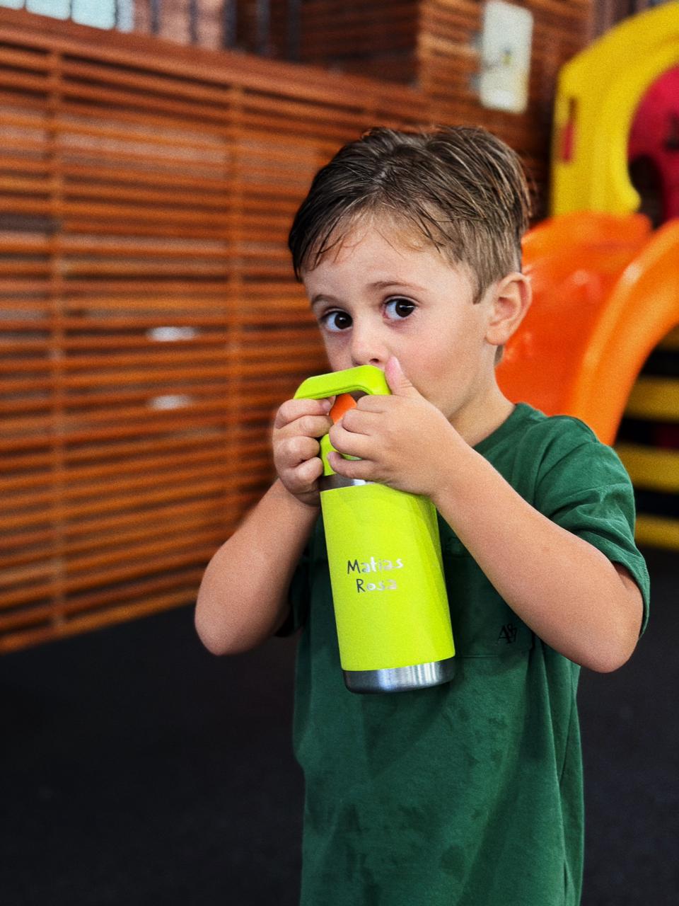 Menino bebendo água na garrafinha GYMEE Kids com o nome gravado